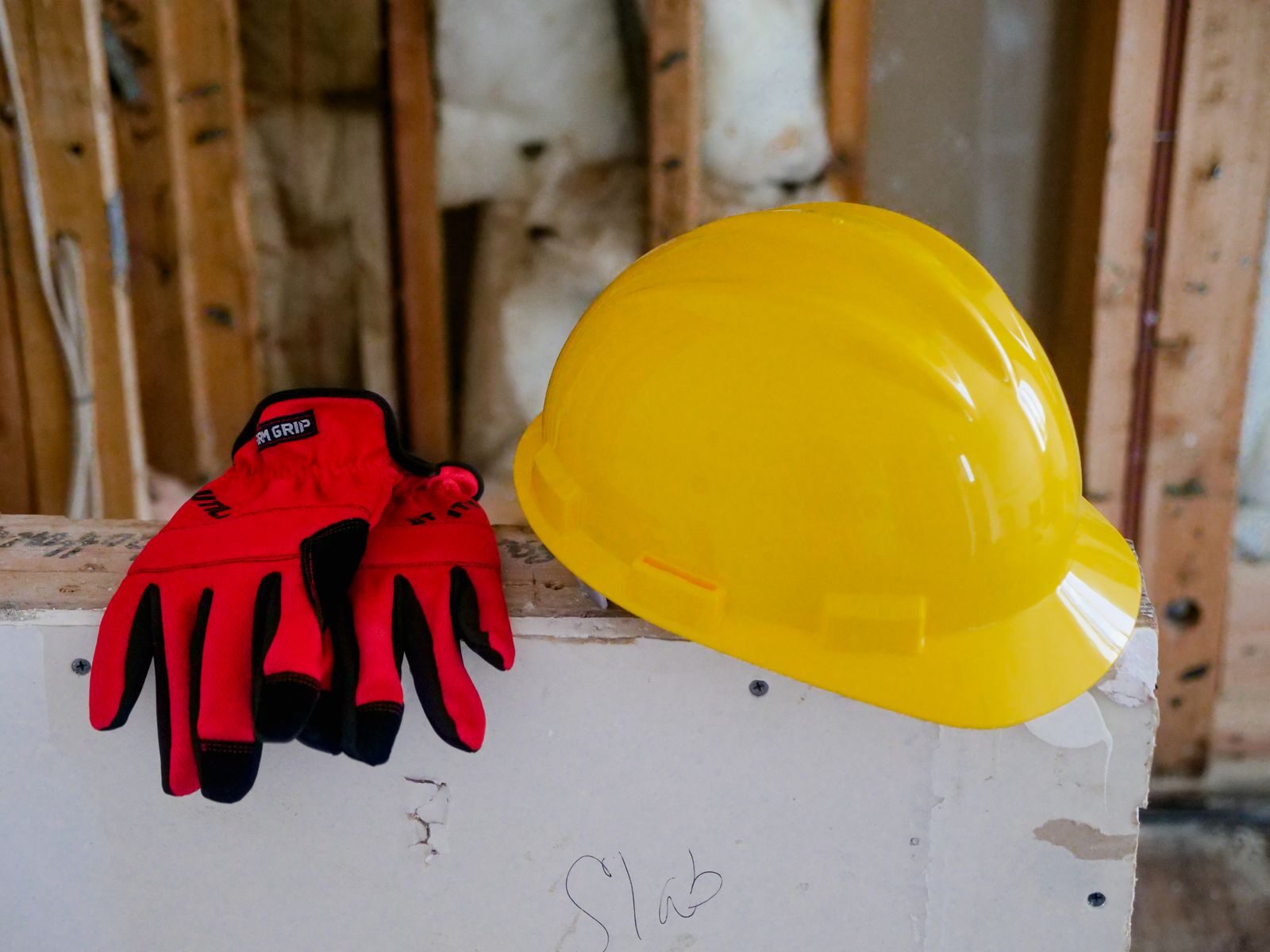 Yellow hard hat and protective gloves at a construction site